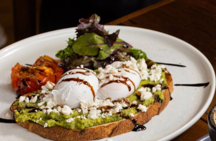 Smashed avocado on toast with poached eggs and fetta